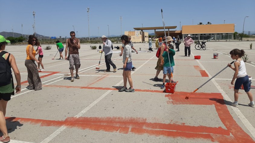 Grup d'activistes, en el moment de fer la pintada, a l'antic pàrquing de taxis