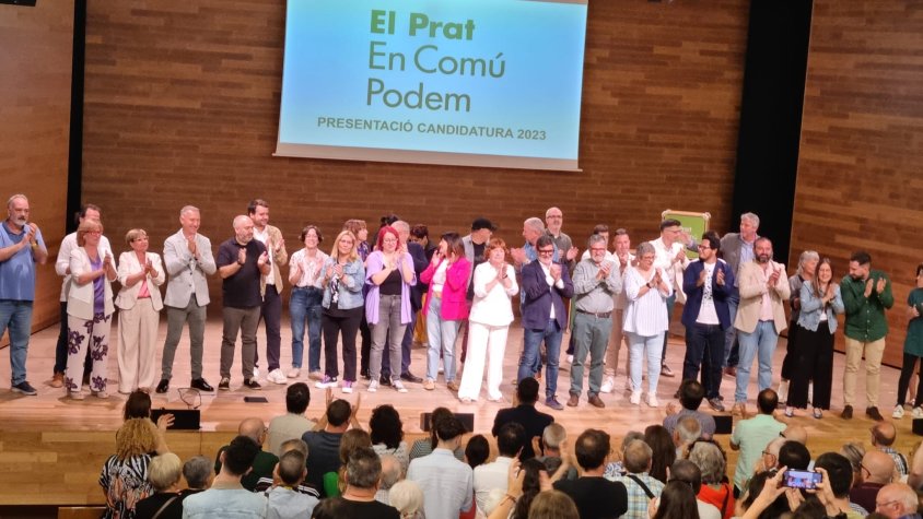 Els 35 membres de la candidatura saluden els assistents entre els acords de 'Benvinguts al Prat'