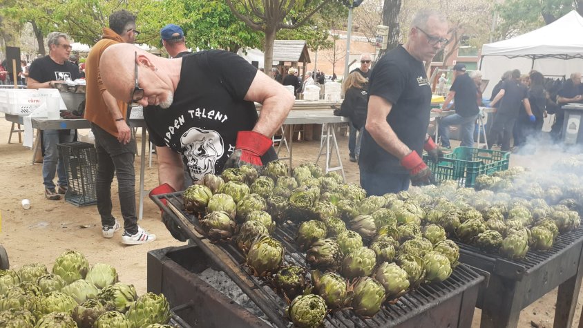 Socis de les Escarxofes s'afanyen a posar a les brases les carxofes del menú