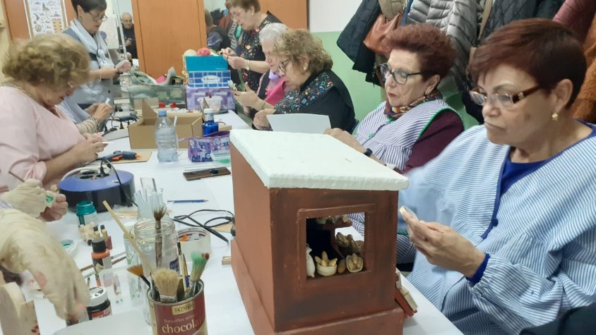 Un grup de voluntàries, treballant en diversos elements del pessebre